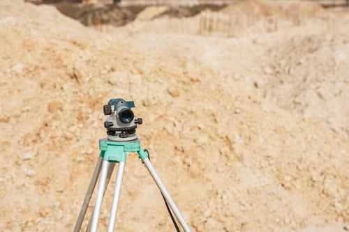 Preview: Digital level on tripod with sand mounds on background