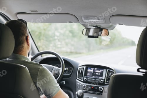 Preview: Young man holding steering wheel while driving car. Road trip adventure