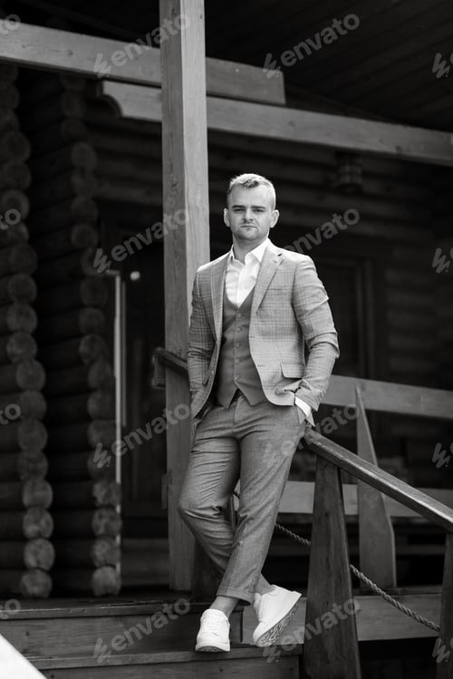 Preview: portrait of the groom in a gray suit and an orange vest