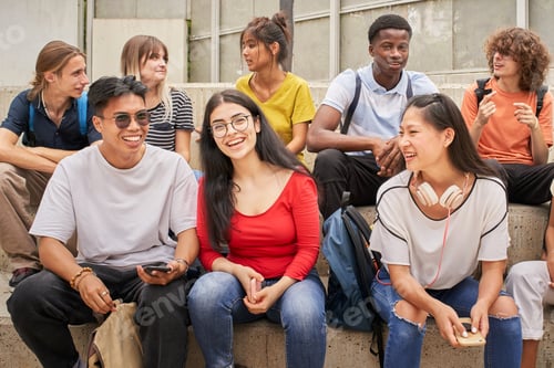 Preview: Group of multi-ethnic students happily looking at the camera during a break.
