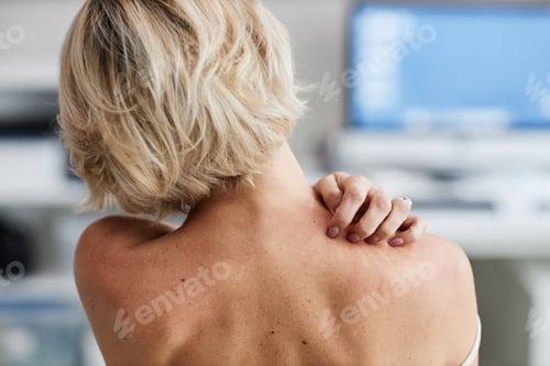 Preview: Middle Aged Caucasian Woman Touching Shoulder While Attending Dermatologist