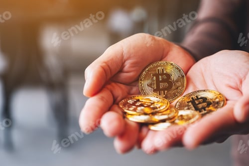 Preview: Closeup image of a woman holding and showing golden color bitcoins in hands