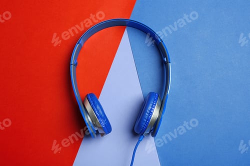 Preview: Stylish headphones on color background, top view