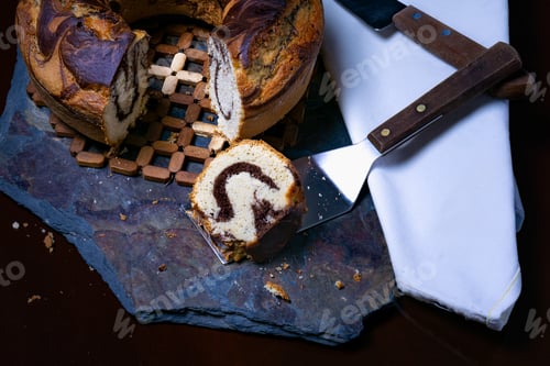 Preview: High angle shot of a delicious homemade marble pound cake on a slate board with kitchen utensils