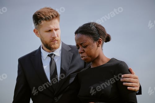 Preview: Caucasian Man Comforting Grieving Black Woman during Outdoor Funeral Ceremony