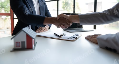 Preview: Two young Asian businessmen shake hands after signing a contract to invest in a village project. rea