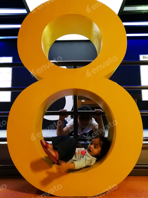 Preview: little girl playing on the number eight statue