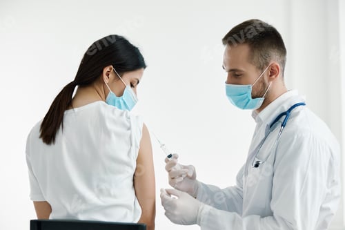 Preview: doctor in medical mask injecting vaccine on woman's shoulder epidemic