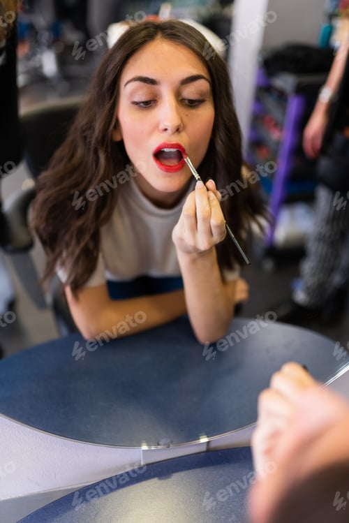 Preview: Attractive woman looking at mirror