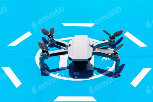 Preview: The drone is standing on a blue landing field, the plastic propellers are turned off