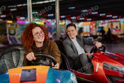 Preview: Cheerful couple enjoys thrilling bumper car ride at amusement park