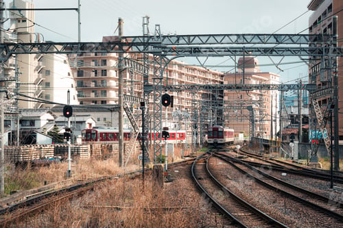 Preview: Local train arrival to station on railway track with wires and building in urban at Kyoto, Japan