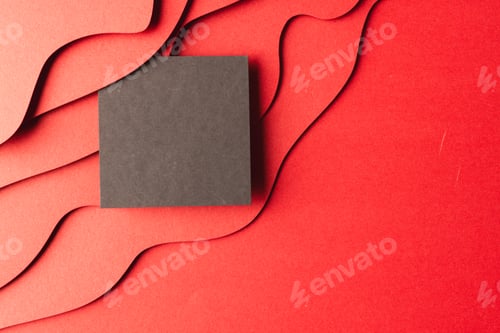 Preview: Square of black paper with copy space on red waves of paper on red background