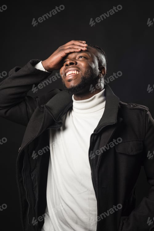 Preview: Man Smiling with Hand on Forehead in Studio