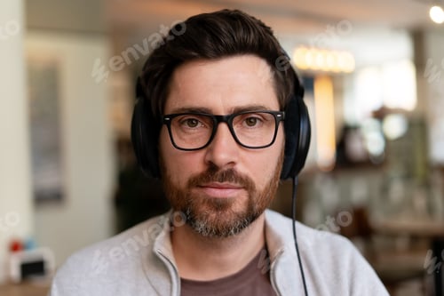 Preview: Man Wearing Headphones and Glasses Indoors