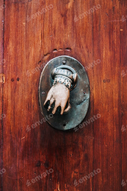 Preview: Bronze metal decoration in hand shape on an old medieval wooden door in Spain, Europe