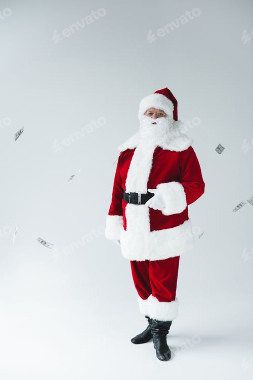 Preview: full length view of santa claus looking at camera and dollar banknotes falling around