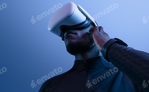 Preview: Concentrated young ethnic man exploring cyberspace in VR glasses