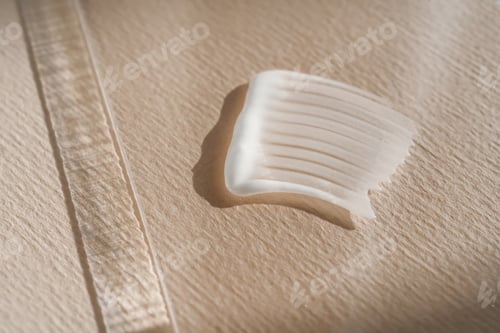 Preview: White cream texture on a beige background.
