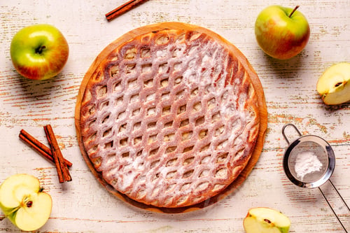 Preview: Homemade apple pie with cinnamon on a wooden background.