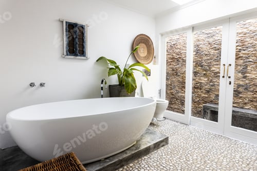 Preview: Modern bathtub with houseplant against white wall in bathroom at home, copy space