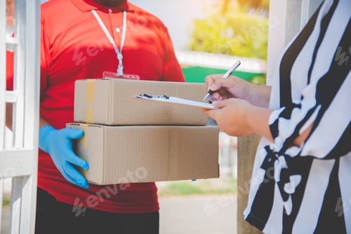 Preview: consumer is signing a document to receive a parcel from a home courier.