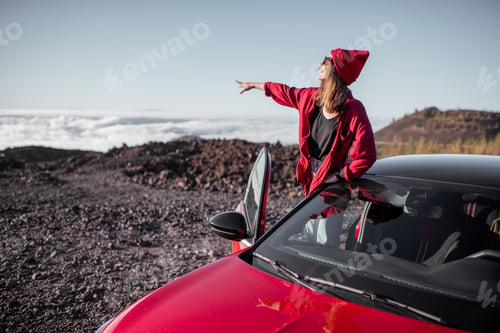 Preview: Woman traveling by car on the rocky terrain above the clouds