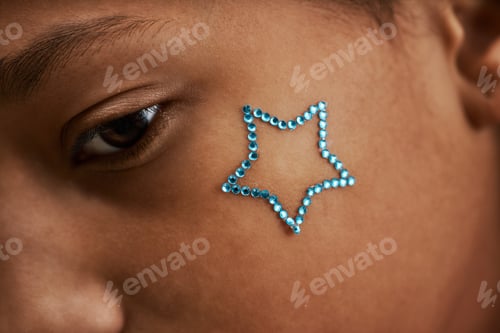 Preview: Macro shot black teenage girl with sparkling tattoo on cheek