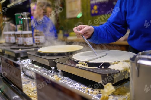Preview: Crop man cooking pancakes at street market