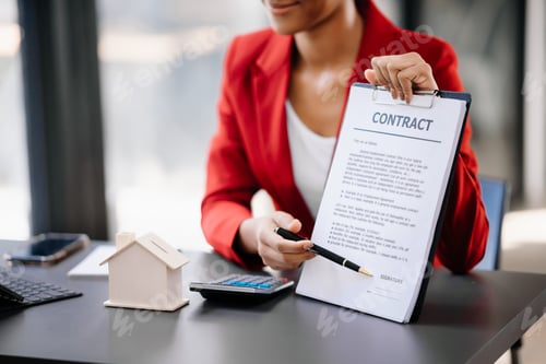 Preview: Young real estate agent worker working with laptop and tablet at table in office and small house