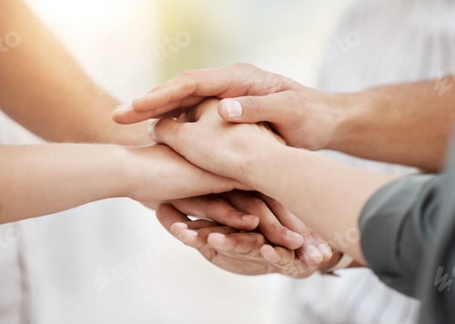 Preview: Closeup of diverse group of people stacking hands together in a pile to express unity, support and