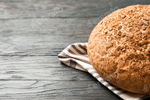 Preview: Bread on kitchen towel on wooden background, space for text and closeup