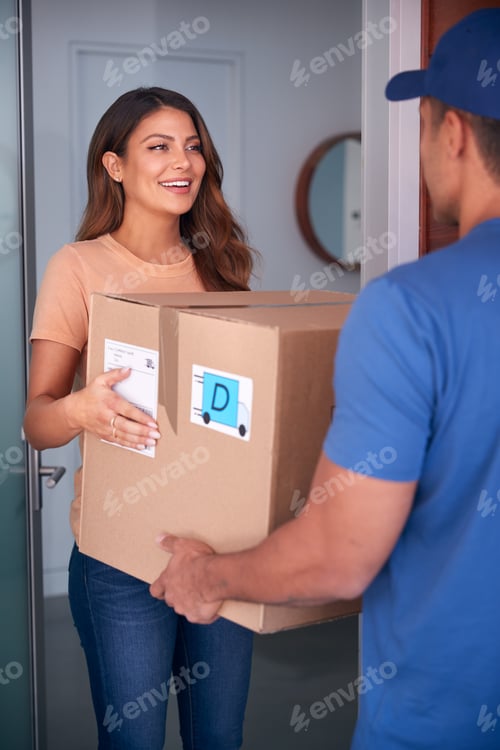 Preview: Woman Receiving Package Delivered By Courier To Home