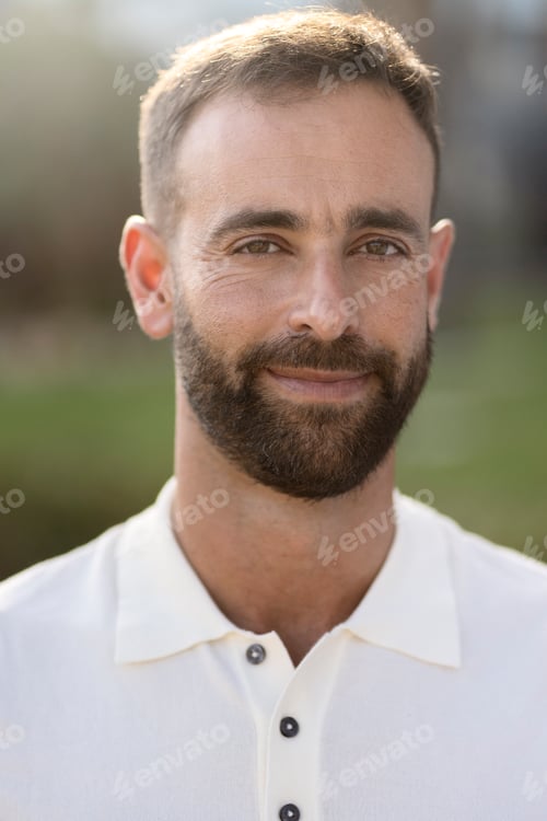 Preview: Confident bearded latin man wearing white t shirt looking at camera outdoors