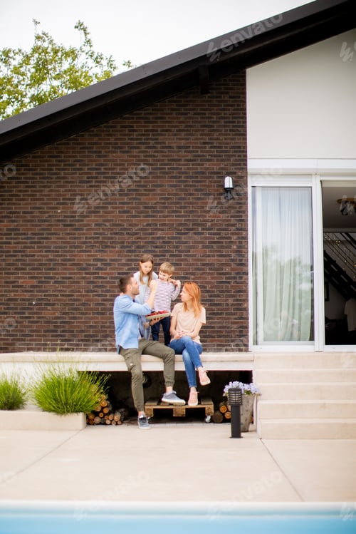 Preview: Family with a mother, father, son and daughter sitting outside on steps