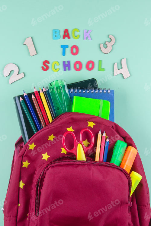 Preview: Red backpack with different colorful stationery on pastel green background. Back to school concept.