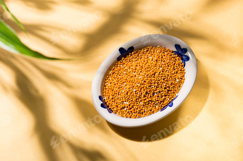 Preview: healthy grains of red millet served in a plate on yellow background