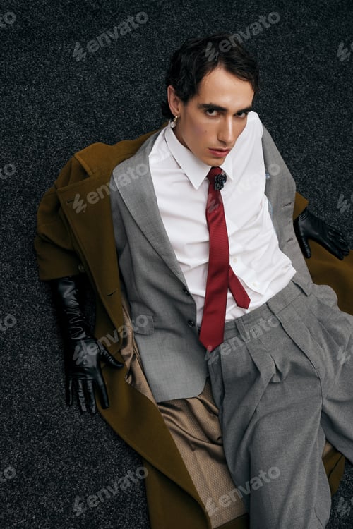 Preview: Stylish man in a gray suit poses confidently in a chic urban setting