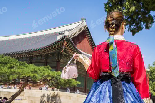 Preview: Woman in traditional Korean clothing in front of a pagoda