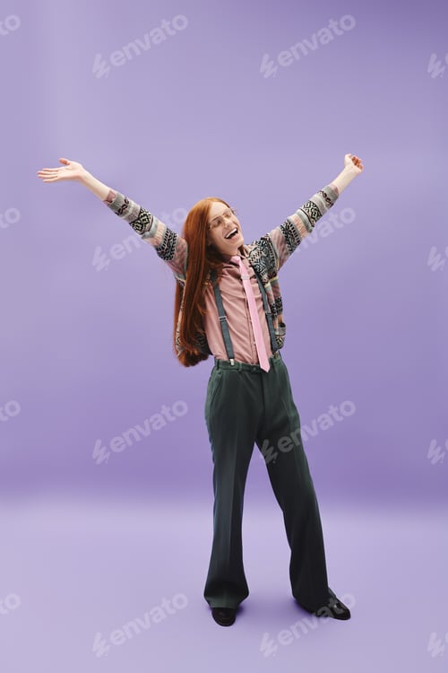 Preview: Stylish young man celebrating individuality with vibrant pose against a purple backdrop