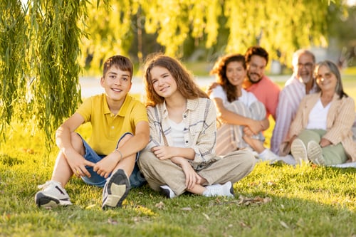 Vista previa: Cheerful caucasian teen boy and girl relax with parents and grandparents, enjoy picnic in park