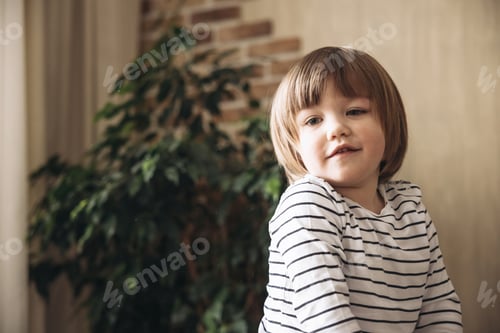 Preview: Portrait of pretty caucasian brunette happy smiling little boy posing having fun and playing at home
