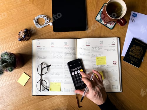 Preview: Overhead workspace view of male hands and working station with notebook, tablet, glasses, calculator