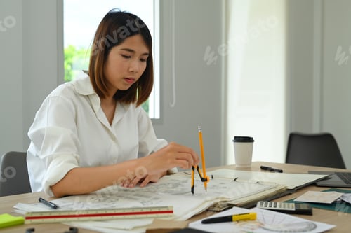 Preview: Focused architect woman inspecting building layout at her workplace.