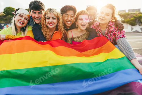 Preview: Young diverse people having fun holding LGBT rainbow flag outdoor - Focus on center girl face