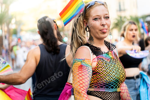 Preview: Woman showing tongue at gay pride parade with rainbow flag