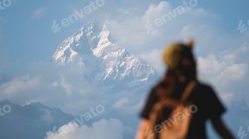 Preview: Blurred rear view of a woman traveler looking at Machapuchare peak, Annapurna mountain
