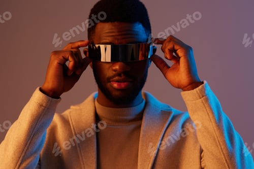 Preview: Stylish young Black man wearing futuristic sunglasses, showcasing confidence and modern fashion