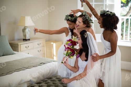 Preview: Bride and bridesmaid taking selfie at home