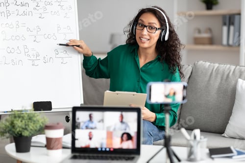 Preview: Young teacher showing board, giving virtual lecture to diverse students